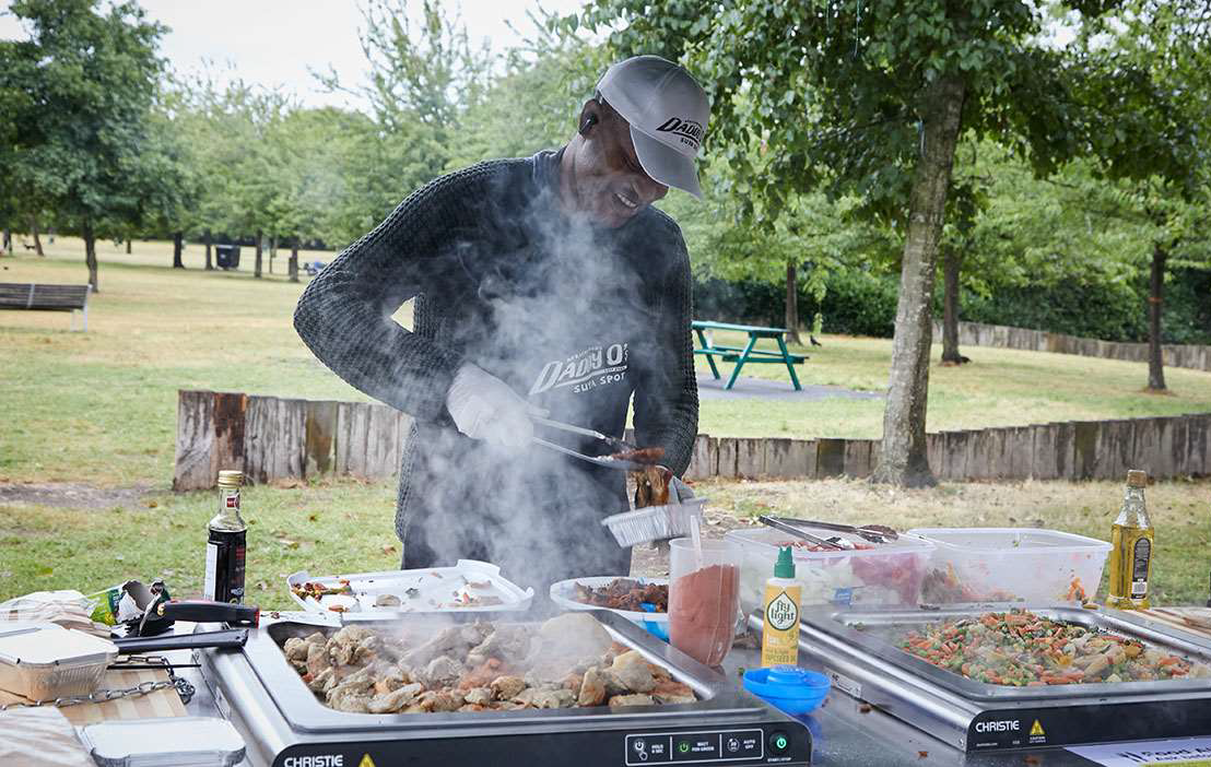 Man is cooking on hotplates in a park